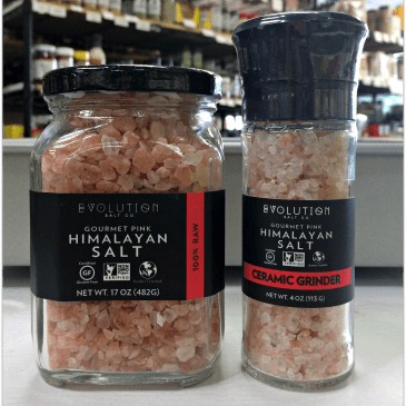 A jar and a ceramic grinder of Evolution brand gourmet pink Himalayan salt.