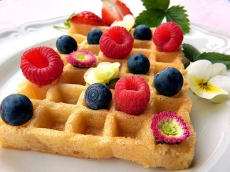 Waffle with fresh red raspberries, blueberries & edible flowers